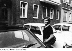 Die Künstlerin Thea Richter zwischen parkenden Autos