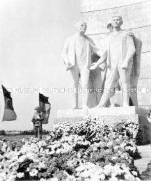 Mahnmal mit Blumen und Kränzen zur Einweihung der Nationalen Mahn- und Gedenkstätte Sachsenhausen