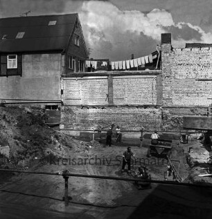 Firma Carl Hoffmann: Hindenburgstraße: Elektrohandel: Neubau: Fundament: Blick in Baugrube mit Baumaterial, Baumaschinen und Arbeitern: hinten links Wohn- und Geschäftshaus und Hinterhaus: darauf Wäscheleine mit Wäsche