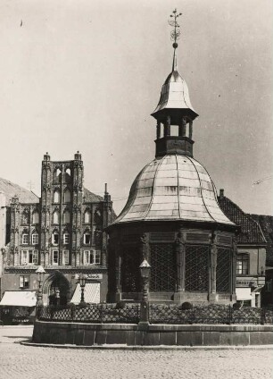 Wismar. Mecklenburg. Ansicht der von 1579 bis 1602 im Stil der niederländischen Renaissance errichteten Wasserkunst, einem zwölfeckigem Brunnenhaus mit Gockendach. Im Hintergrund der "Alte Schwede", ein 1360 erbautes backsteingotisches Bürgerhaus
