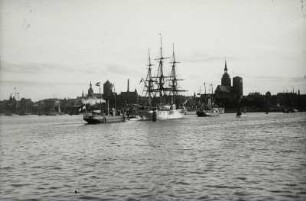 Stralsund, Hafen, Segelschulschiff der schwedischen Marine mit zwei Bugsierdampfern auf der Fahrt zum Liegeplatz mit Blick auf die Altstadt