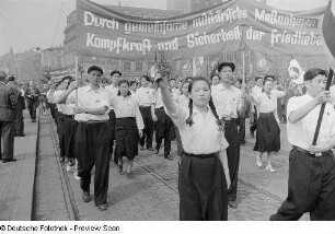 Asiatische Teilnehmer im Demonstrationszug beim Vorbeimarsch an der Ehrentribüne auf dem Karl-Marx-Platz (heute: Augustusplatz), im Hintergrund das Kroch-Hochhaus