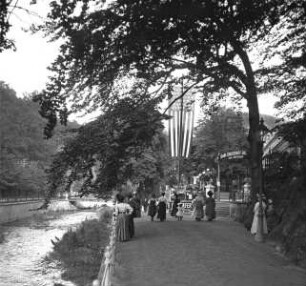 Promenade mit Kurgästen an der Tepl vor einem Gartenrestaurant in Karlsbad