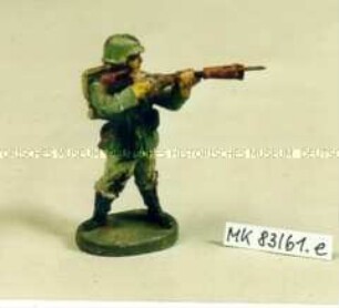 Spielzeugsoldat: Soldat mit Marschgepäck, stehend schießend