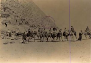 Gizeh, Ägypten. Touristengruppe der Hapag auf Kamelen und Eseln mit Fremdenführern am Fuß einer Pyramide