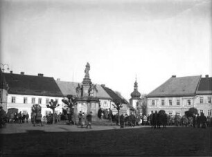 Deutschland. Naturfreundetreffen. Wandergruppen auf dem Marktplatz einer Ortschaft. Blick gegen Marienstatue und Kirchturm