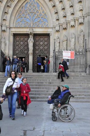 Barcelona - Behinderter im Rollstuhl bettelt : Vor der Kathedrale sitzt ein behinderter Mann in seinem Rollstuhl und bettelt Passanten an. Aufgenommen am 15. April 2012 in Barcelona