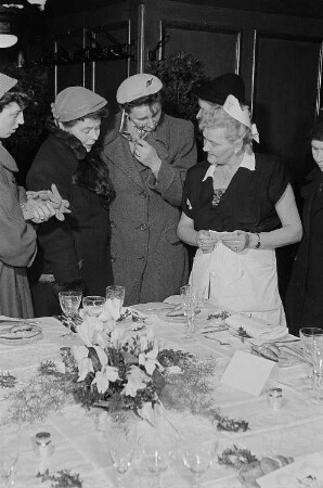 Besucherinnen und Servicepersonal vor einem festlich gedeckten Tisch in einer Küchenausstellung im Sachsenhaus