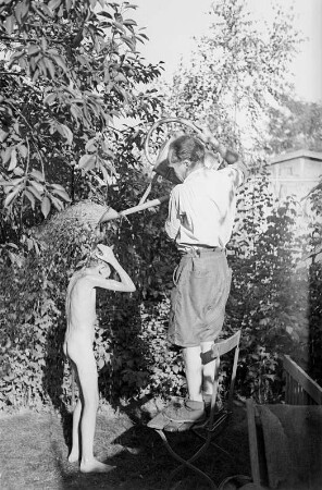 Porträt von Walter Dehmel mit Familie im Garten : Walter Dehmel duscht seinen Enkelsohn mit der Gießkanne