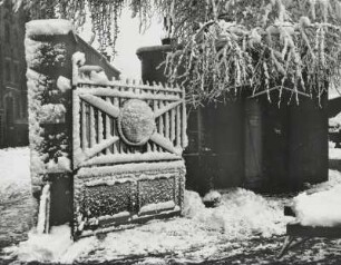 Flügel eines geöffneten Tores mit Pförtnerhäuschen nach einem Schneetreiben
