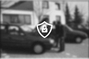 Autohaus [Name maskiert] Gänseberg: Peugeot-Vertragshändler: Parkplatz: Kraftfahrzeugmeister Hans-Joachim Schmelling an geöffneter Motorhaube von Peugeot-Pkw: gibt Erklärungen an Kunde: daneben Pkws: 19. März 1990