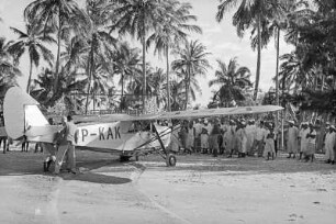 Flugzeug am Strand von Lindi : Eine Gruppe von Personen an einem Flugzeug