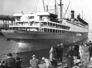 Hamburg. Das 1932/33 gebaute Turbinenpassagierschiff "Washington" verlässt den Hamburger Hafen. Am Kai stehen die Daheimgebliebenen