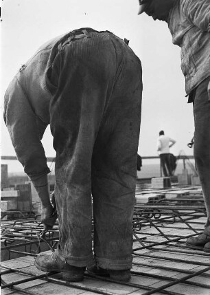 Arbeiter beim Flechten von Bewehrungsmatten auf einer Baustelle