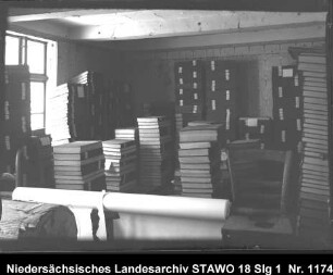Braunschweigisches Landeshauptarchiv/Niedersächsisches Staatsarchiv in der Alten Kanzlei, Wolfenbüttel [um 1950] Enthält: Gestapelte Archivalien (gebundene Zeitungsbände ?)