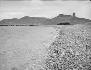 Kieselstrand mit Berlandschaft im Hintergrund