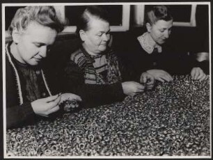 Frau beim Aussortieren von Bauteilen