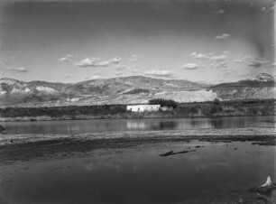 Landschaft : Blick über ein Gewässer auf die Landschaft mit einem Gebäude im Mittelpunkt.