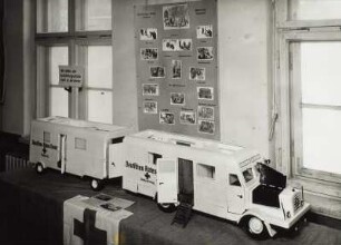 Modell eines Röntgen- und Ambulanzzuges vom Deutschen Roten Kreuz vor Wandzeitung der Abteilung Roßwein des DRK