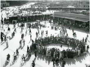 Straßenkünstler auf dem Djemaa el Fna : Eine Menschenmenge hat sich auf dem Djemaa el Fna um einen Straßenkünstler versammelt. Der Djemaa el Fna ist der zentrale Marktplatz in der marokkanischen Stadt Marrakesch.