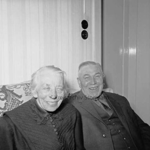 Hafemann, Gustav und Frieda, geborene Voß: Gustav geboren 1889: Eigentümer der Ziegelei in Westerau; ehemaliger Amtswehrführer des Amtes Reinfeld-Land: Einwohner von Westerau: Aufnahme aus Anlass ihrer Goldenen Hochzeit am 26. Februar 1965: in ihrer Privatwohnung, auf Sofa