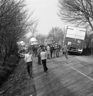 Verkehrsunfall: Landstraße zwischen Hammoor und Bargteheide: Langehorst / Lohe: Kollision eines VW-Käfer mit einem Lkw: rechts verunglückter Lkw im Straßengraben: links Unfall-Pkw: dazwischen mehrere Polizisten, Helfer und Zuschauer: hinten Mitte Feuerwehrfahrzeug, Lkws und Polizeifahrzeug: rechts und links Bäume und Büsche