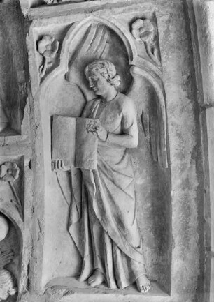 Südliches Westportal — Rechte Archivolte — Ein Engel mit geöffnetem Buch
