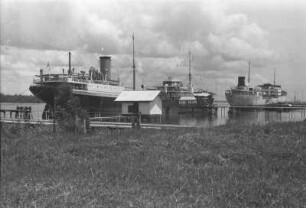 Tankschiffe zur Öleinnahme : Hafenlandschaft mit Dampfschiffen