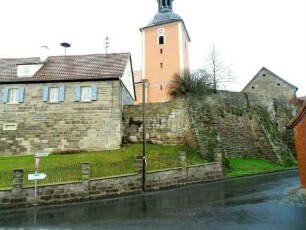 Evangelische Pfarrkirche-Ansicht von Südsüdosten mit Kirchturm (im Kern Frühgotisch) über Kirchhofmauer (Wehrgang mit Steinbrüstung im 19 Jh abgetragen) sowie alter Schule