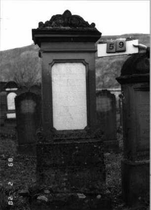 Grabstein 59 (Index: 99798599) Material: Sandstein, Schriftplatte Marmor Zustand: gut Maße HxBxT: 184x47x26 cm Beschreibung: Stele mit Volutenaufsatz, Schriftplatte mit geradem Abschluß, Sockel: Grabstein 59