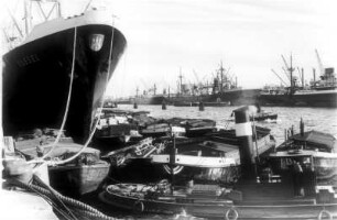 Hamburg. Hafen. Der Stückgutfrachter "Kassel" der HAPAG (Hamburg-Amerika-Linie) wird am Kai entladen. Er gehört zum Typ "Stuttgart". Am Schiff haben Schuten festgemacht. Im Vordergrund ein Schlepper