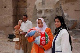 Luxor - Frauen im Luxor-Tempel : Ägypter posieren vor einer Ramses II. Statue im Luxor-Tempel von Luxor, aufgenommen 2006