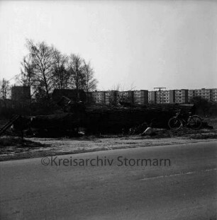 Schanzenbarg: Wohnblocks vor Fertigstellung: vorn Sehmsdorfer Straße: dahinter Büsche und Bäume: vorn rechts Fahrrad