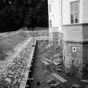 Restaurierung: innerer Graben: neue Grabenversteifung mit Holzbohlen am Grabenfuß: Grabenböschung nach Wiederherstellung mit alten Findlingen: saniertes Schlossfundament nach Abbau von Gerüst
