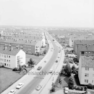 Gartenstadt Falkenberg: Stonsdorfer Weg mit Wohngebäuden und parkenden Pkws, im Hintergrund das Gewerbegebiet Stonsdorf: Blick vom Rathausgebäude Richtung Osten