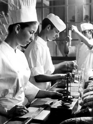 Bäckerlehrlinge während ihrer Ausbildung. Ein Lehrling wiegt ein Teigstück. Aufgenommen 1967