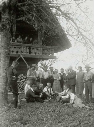 Feriengäste und Einheimische beim Kartenspiel vor einem Bauernhaus