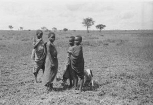 Wambulukinder : Eine afrikanische Kindergruppe mit einem Hund in einer Savanne