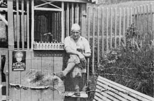 verkleideter Mann vor einer Gartenlaube während eines Freizeitausfluges