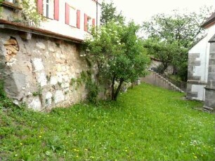 Kirchhof im Osten mit Kirchhofmauer (Wehrgang mit Steinbrüstung und Schießscharten im 19 Jh abgetragen) in übersichtlichem Verlauf nach Süden