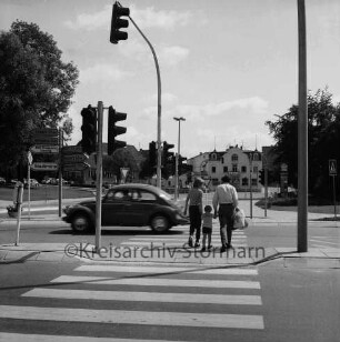 Kreuzung Kurparkallee, Sülzberg, Mewesstraße und Brunnenstraße: neue Ampelanlage mit Fußgängerüberwegen, Verkehrsinseln, Verkehrsschildern: in der Mitte Passanten und Pkw: hinten links und rechts Kurpark: im Hintergrund Mitte Verwaltungsgebäude des Amtes Bad Oldesloe-Land, Einmündungen Bangertstraße und Bergstraße, Park-Hotel