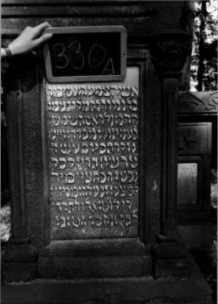Grabstein 330 (Index: 100111958) Material: Sandstein, weiße Marmorplatte Zustand: verwittert Maße HxBxT: 245x76x46 cm Beschreibung: ädikulaartige Stele mit Säulen, getreppter Sockel, Giebel mit Mittel- und Eckakroteren, rechteckige Schriftplatten Symbolik: Blüten, Ranken / Zahnfries: Grabstein 330A