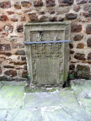 Totenkirche (Romanische Gründung)-Seitenschiff Nord Innen - Nordwand - Exemplarischer Grabstein mit Wappenkartuschen und Umschrift (teils stark verwittert aus dem ehemaligen Kirchhof)