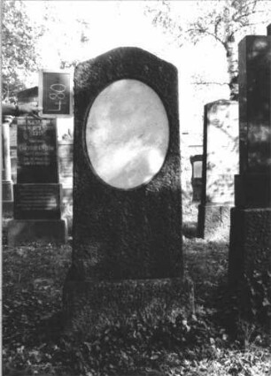 Grabstein 480 (Index: 100111656) Material: Granit, weiße Marmorplatte Zustand: gut, Schriftplatte ohne Inschrift Maße HxBxT: 160x55x21 cm Beschreibung: konische Stele, Sockel, Konvexbogenabschluß, ovale Schriftplatte: Grabstein 480