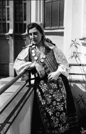 Bukarest: Wohnung Suter, Fräulein Zaharescu im Banater Kostüm [Tracht], auf Balkon
