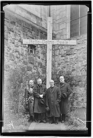 Königstein. Geistliche Vertreter der katholischen Kirche vor Holzkreuz mit Aufschrift "Rette Deine Seele!"