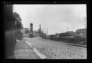 Courrières (Dep. Pas-de-Calais, Frankreich): Gebäude und Uhrturm [der Brückenfabriken] an einem Kanal (Distanzaufnahme)