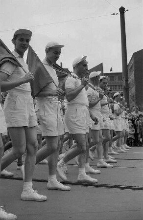 Sportler (Tennisspieler?) auf einer Parade anlässlich des II. Deutschen Turn- und Sportfestes mit Fahnen