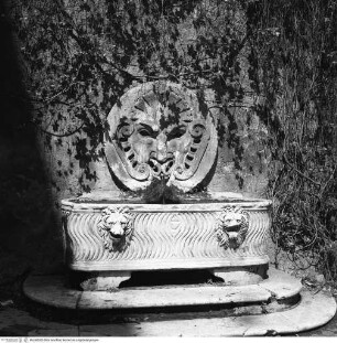 Brunnen mit Mascherone und antikem Sarkophag