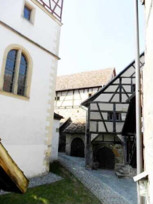 Kirchhof im Nordosten mit Kirchturm (Chorturm mit Turmchor) sowie Gaden-veranschaulichend die engen Verhältnisse